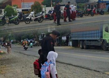 Personel Batalyon D Pelopor Bantu Penyeberangan Siswa di Hari Pertama Sekolah