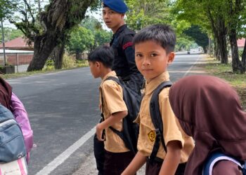 Personel Batalyon D Pelopor Bantu Penyeberangan Siswa SDN 28 Mancani Demi Keselamatan di Jalan Raya